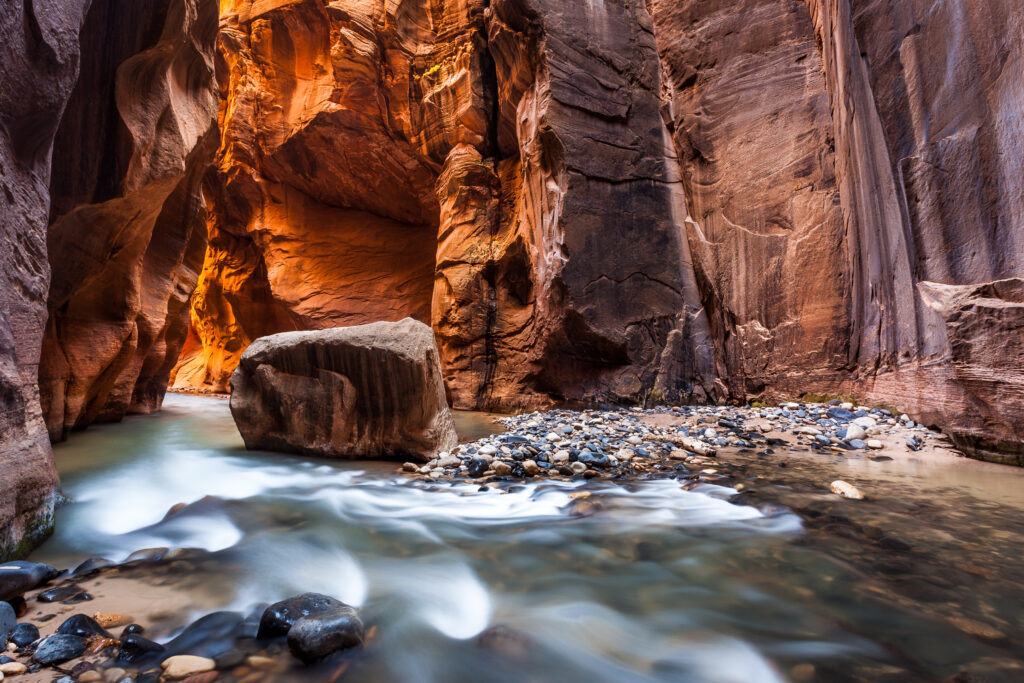 The Virgin River flowing through Wall Street in Zion's Narrows — water finding its direct path between towering sandstone walls, moving at the pace the terrain demands.